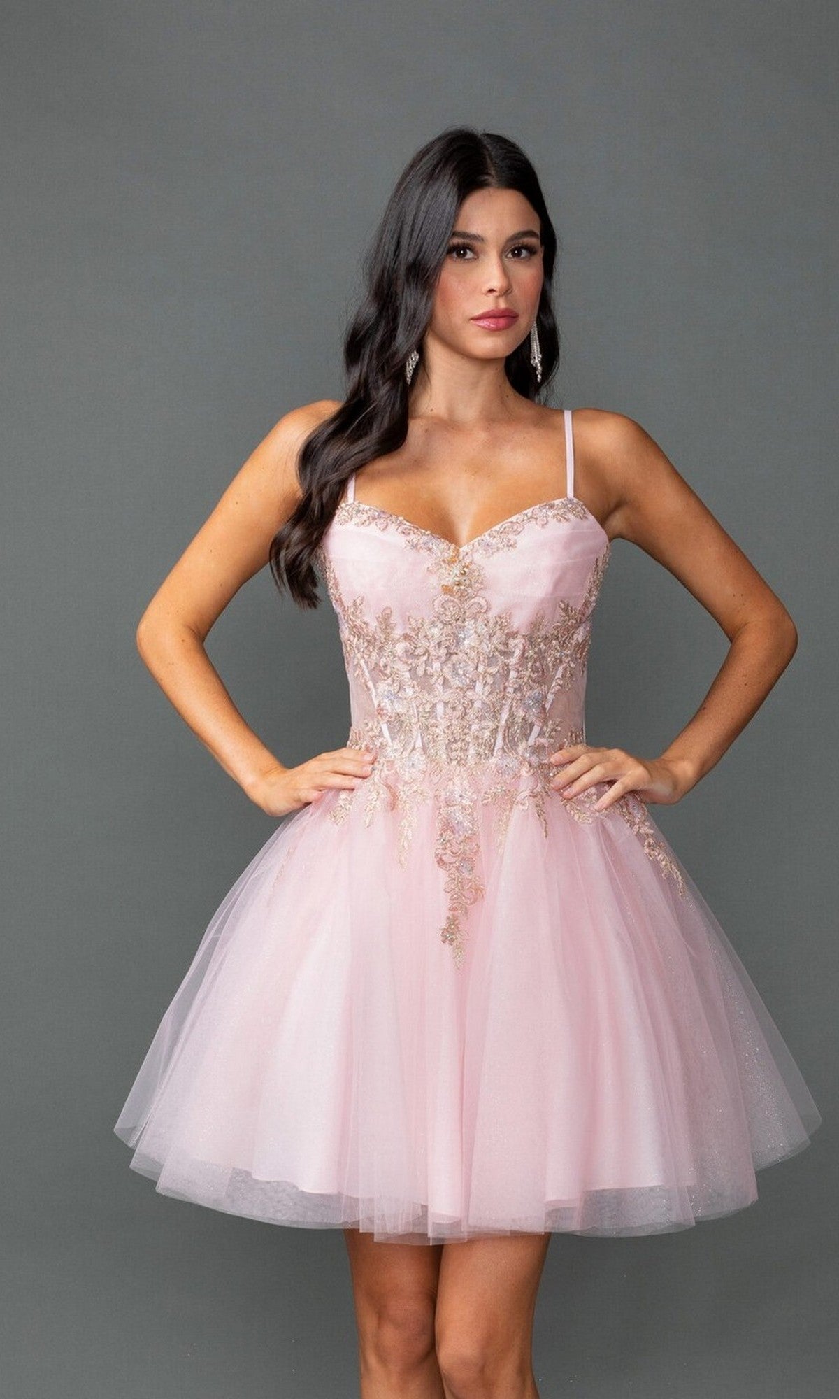 A woman poses against a gray background wearing the Dancing Queen 3424 short prom dress, featuring a sheer corset bodice, gold embroidery, and thin straps.